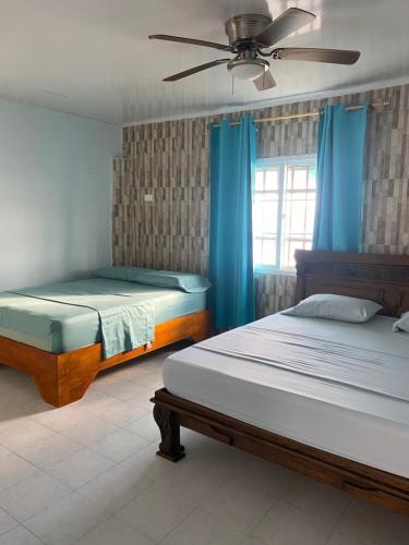 a bedroom with two beds and a ceiling fan at CASA DE PLAYA ROCKY CAY BAY in Cueva de Morgan
