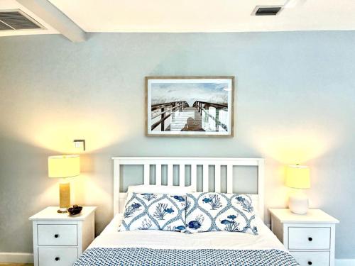 1 dormitorio con 1 cama con paredes azules y una foto en la pared en Capri Inn & Apartments, en Lake Worth