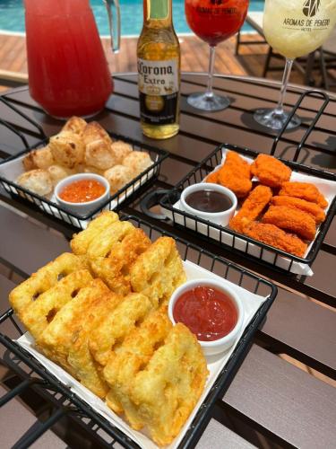 a table topped with trays of food and drinks at Hotel Aromas de Penedo in Penedo