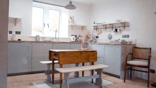 a kitchen with a wooden table and a counter at Woodview Cottage in Glamis