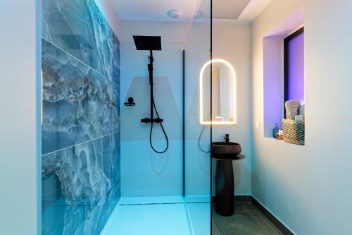 a bathroom with a shower with blue tiles at Romance Spa Nuit D'amour in Le Havre