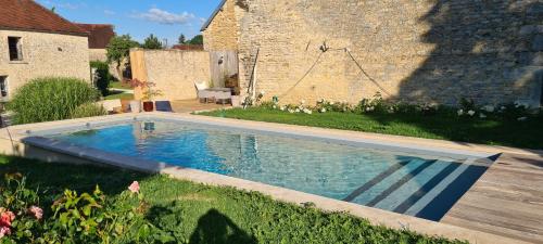 a swimming pool in the yard of a house at La villa des Chouettes in Maisons-lès-Chaource