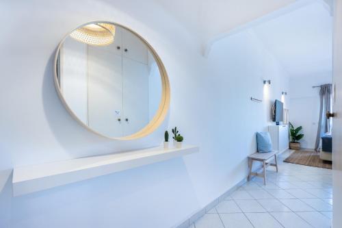 a round mirror on a white wall in a bathroom at Studio Marina View by Seewest in Lagos