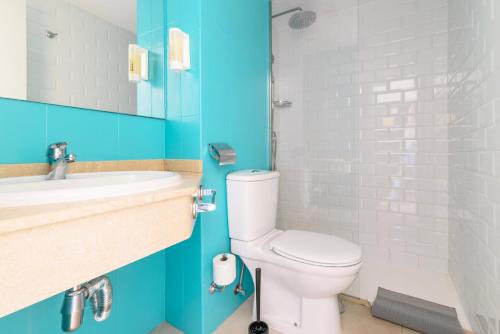 y baño con aseo, lavabo y ducha. en Apartment in resort en Corralejo