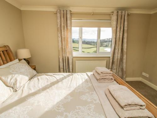 a bedroom with a bed with two towels on it at The Marshes in Welshpool