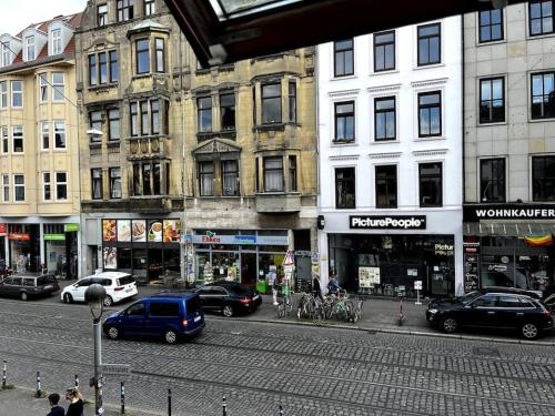 een drukke straat met auto's geparkeerd voor gebouwen bij EXKLUSIVE Wohnung mitten im schönsten Viertel in Bremen