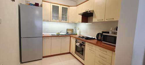 a kitchen with white appliances and wooden cabinets at Apartman Botivo in Ludbreg