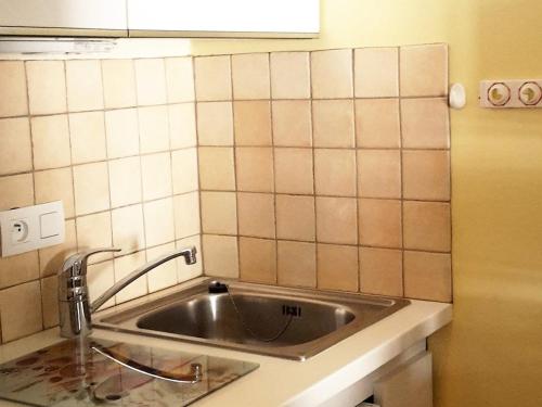 Il dispose d'une cuisine avec un évier et un mur carrelé. dans l'établissement Appartement 32m², centre Croisette, 5 couchages, Wifi, animaux admis - FR-1-574-25, aux Menuires