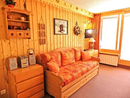 un salon avec un canapé et une télévision dans l'établissement Bel appart rénové 32m², 4 pers, au pied des pistes, centre station, balcon, wifi, animaux OK - FR-1-574-36, aux Menuires