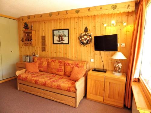 un salon avec un canapé et une télévision à écran plat dans l'établissement Bel appart rénové 32m², 4 pers, au pied des pistes, centre station, balcon, wifi, animaux OK - FR-1-574-36, aux Menuires