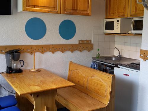 une cuisine avec une table en bois et un réfrigérateur dans l'établissement Studio charmant pour 4 pers. balcon sud, quartier Reberty, Les Menuires - FR-1-574-23, aux Menuires