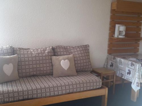 - un canapé avec deux oreillers dans l'établissement Appartement 4 pers. au pied des pistes avec balcon - Les Belleville - FR-1-574-31, aux Menuires