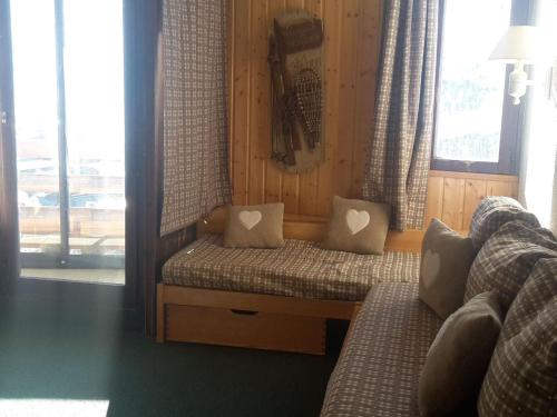 Cette chambre comprend un banc avec des oreillers et une fenêtre. dans l'établissement Appartement 4 pers. au pied des pistes avec balcon - Les Belleville - FR-1-574-31, aux Menuires