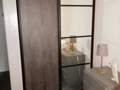 La salle de bains est pourvue d'une porte coulissante en verre et d'une lampe. dans l'établissement Appartement cosy pour 4, pieds des pistes, Les Menuires, wifi, animaux ok - FR-1-574-42, aux Menuires