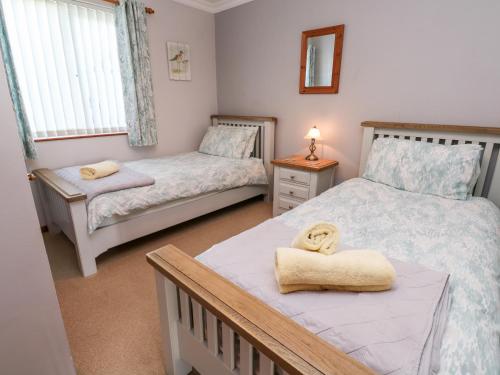 a small bedroom with two beds with towels on them at Salakee in Penzance
