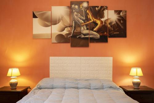 1 dormitorio con 1 cama con 4 cuadros en la pared en Ginevra Vista Mare, en Campobello di Mazara
