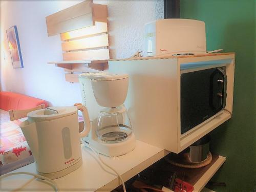 un comptoir de cuisine avec un four micro-ondes et un mixeur dans l'établissement Charmant 4p, Wi-Fi, animaux admis, Les Menuires - Croisette - FR-1-574-33, aux Menuires