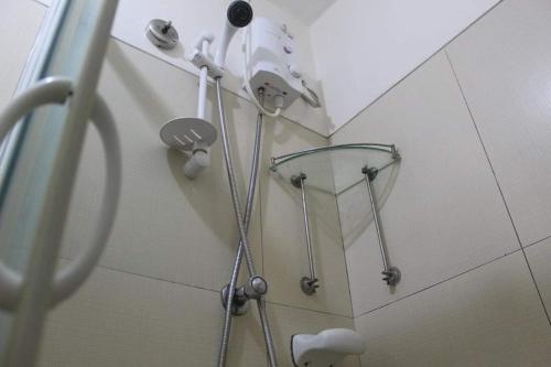 um chuveiro na casa de banho com uma cabeça de chuveiro em CHATEAU ELYSEE A11 Near Sm Mall and Airport em Manila