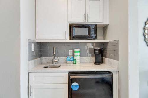 a kitchen with white cabinets and a sink and a microwave at Luau #6633 in Destin