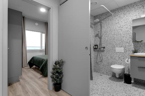 a bathroom with a shower and a bed and a toilet at B20 Apartments in Reykjavík