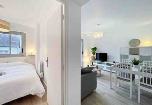 a white bedroom with a bed and a desk at L'escapade - Centre Ville - Parking - Balcon in Rennes