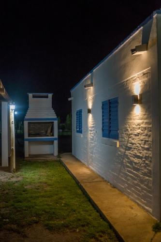 a white building with blue shuttered windows at night at Complejo Willy Pampa in Barreal