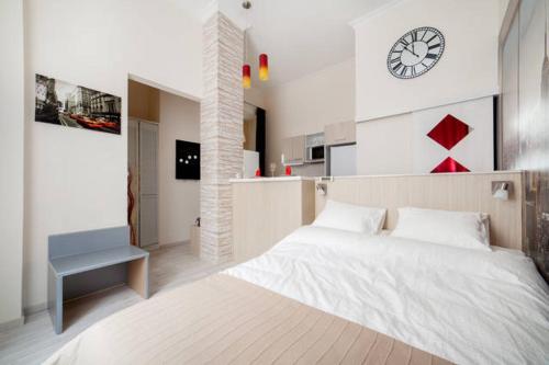 a bedroom with a large bed and a clock on the wall at Manhattan Studio in Budapest