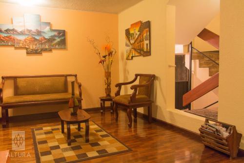 a living room with a couch and two chairs at Altura Rooms & Suites in Quito