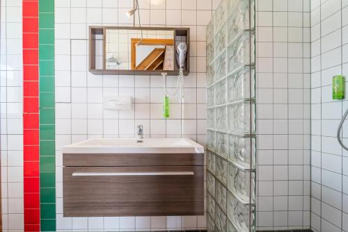 un bagno con lavandino e specchio di Hotel Inn Salland a Raalte