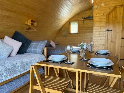 ein Wohnzimmer mit einem Tisch und einem Sofa in der Unterkunft Cosy Cabins at Westfield Farm in Yarmouth