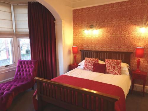 a bedroom with a bed and a purple couch at Fraoch House in Edinburgh