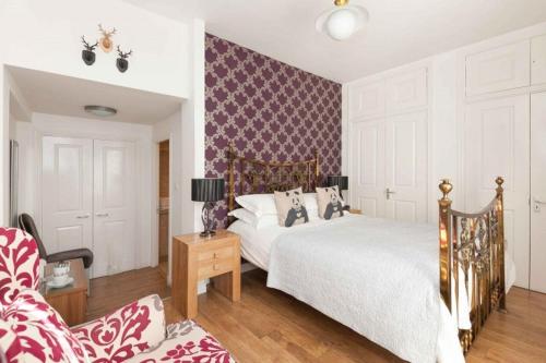 a bedroom with two beds and a purple and white wall at Fraoch House in Edinburgh