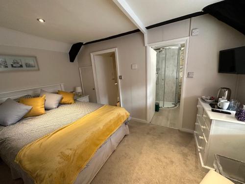 1 dormitorio con 1 cama con sábanas amarillas y ventana en Cottage en-suite room with private lounge, en Bridport