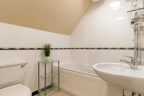 a bathroom with a sink and a toilet and a tub at Hotel Plas Hyfryd in Narberth