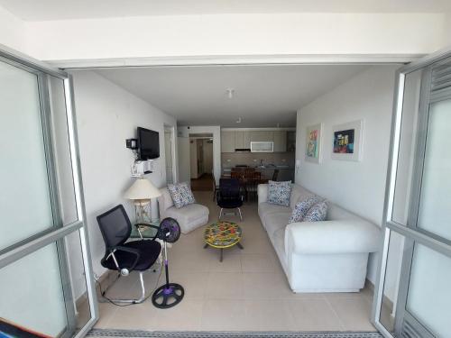 sala de estar con sofá blanco y sillas en Apartamento Aqualina Orange Decimo Piso 2 Habitaciones Vista a Montañas, en Girardot