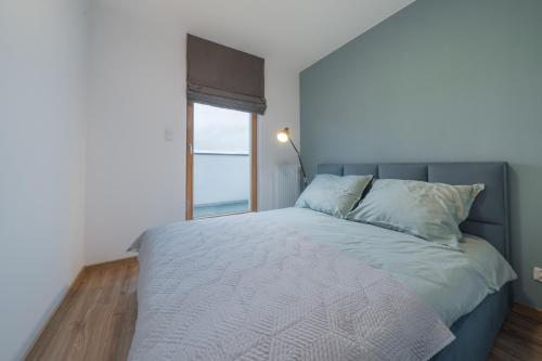 a bedroom with a large bed with a window at Apartament Kapitalny in Gdańsk