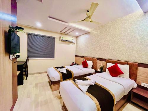 Cette chambre comprend 3 lits et une télévision. dans l'établissement HOTEL SM DECCAN PARK, à Shamshabad