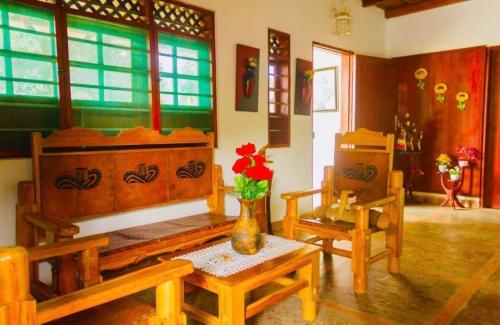 a living room with wooden furniture and a vase with a flower at Cabaña Villa Maria in San Antero