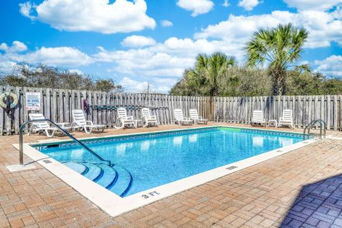 a swimming pool with chairs and a fence at La Playita & Flip Flop Fun in St. George Island