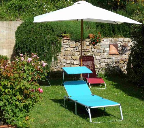 a blue table and a chair under an umbrella at Podere Sant'Angelo in Roccalbegna