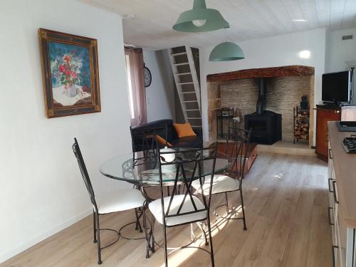 a dining room with a glass table and chairs at Séjournez au cœur du Périgord - La P'tite Maison, gîte de charme à Carlux, près de Sarlat in Carlux