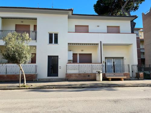 een wit huis met een bankje ervoor bij Appartamento Mareadi in Marina di Grosseto