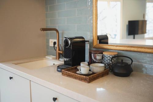 una encimera de cocina con cafetera y tazas. en Oever House, en Amberes