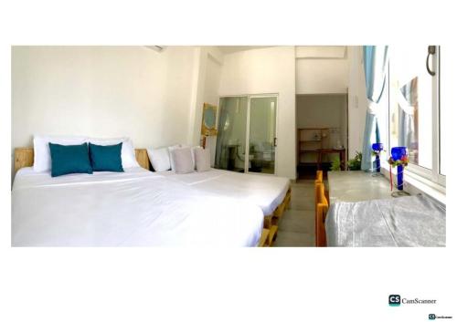 KatuneriyaにあるAyona Beach Villaのベッドルーム1室(白い大型ベッド2台、青い枕付)