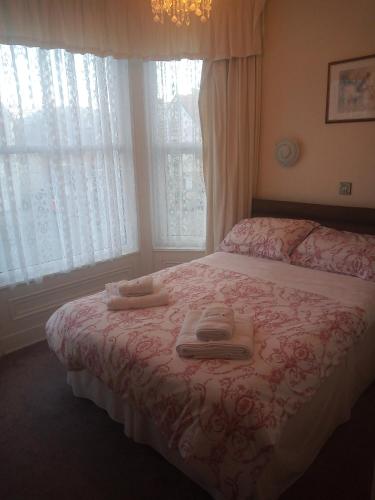 een slaapkamer met een bed met twee handdoeken erop bij Wedgwood Guest House in Llandudno