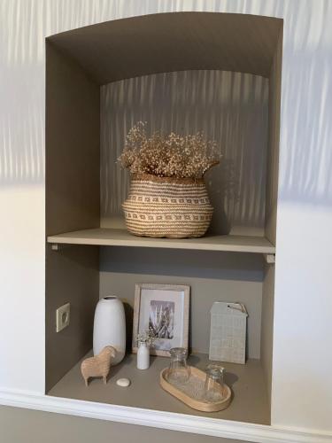 a shelf with a basket and a vase on it at Chambre d'Hôtes La Villa Molina in Besançon