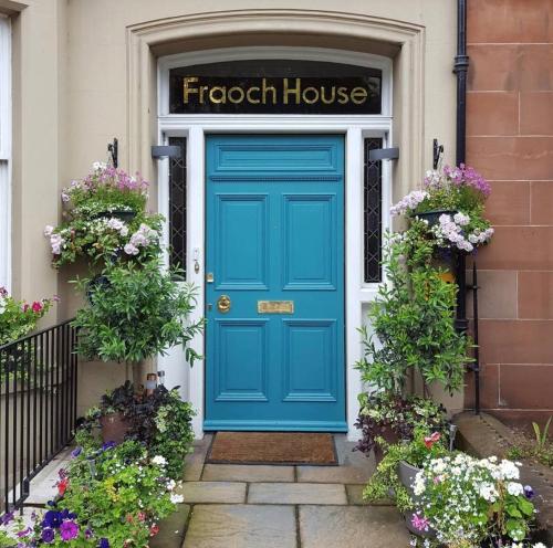 eine blaue Tür vor einem Haus mit Blumen in der Unterkunft Fraoch House in Edinburgh