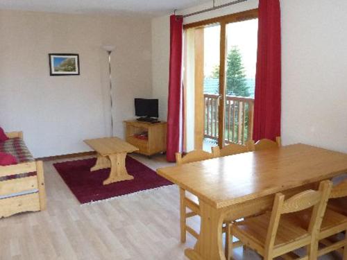 uma sala de estar com uma mesa de madeira e um quarto com uma janela em Appartement Valfréjus, 3 pièces, 6 personnes - FR-1-265-183 em Valfréjus