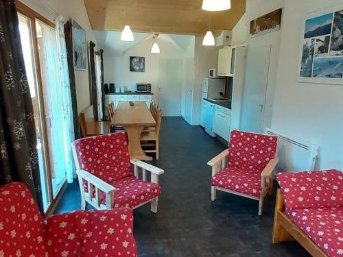 sala de estar con sillas rojas y mesa en Appartement Valfréjus, 5 pièces, 12 personnes - FR-1-265-180, en Valfréjus