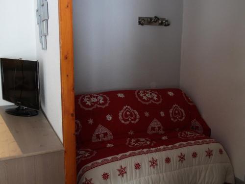 ヴァルフレジュスにあるAppartement Valfréjus, 3 pièces, 6 personnes - FR-1-265-221の赤い毛布付きのベッドが備わる小さな客室です。